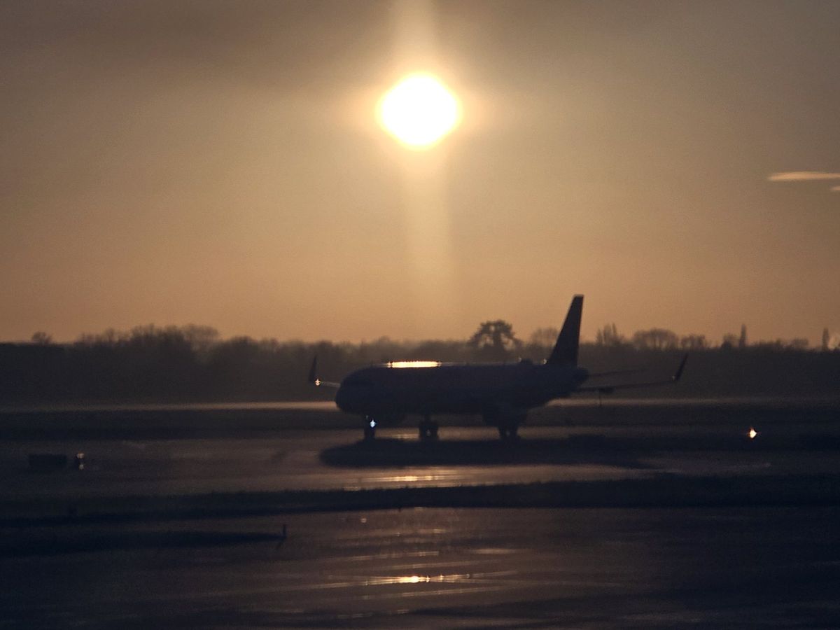 A plane taxiing out at sunrise