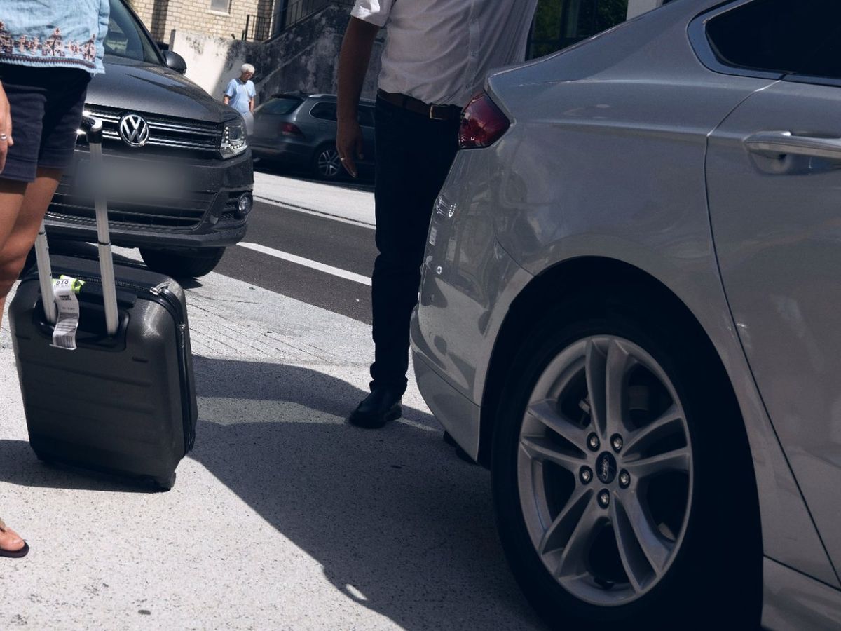 A suitcase by an open car boot, ready for the airport